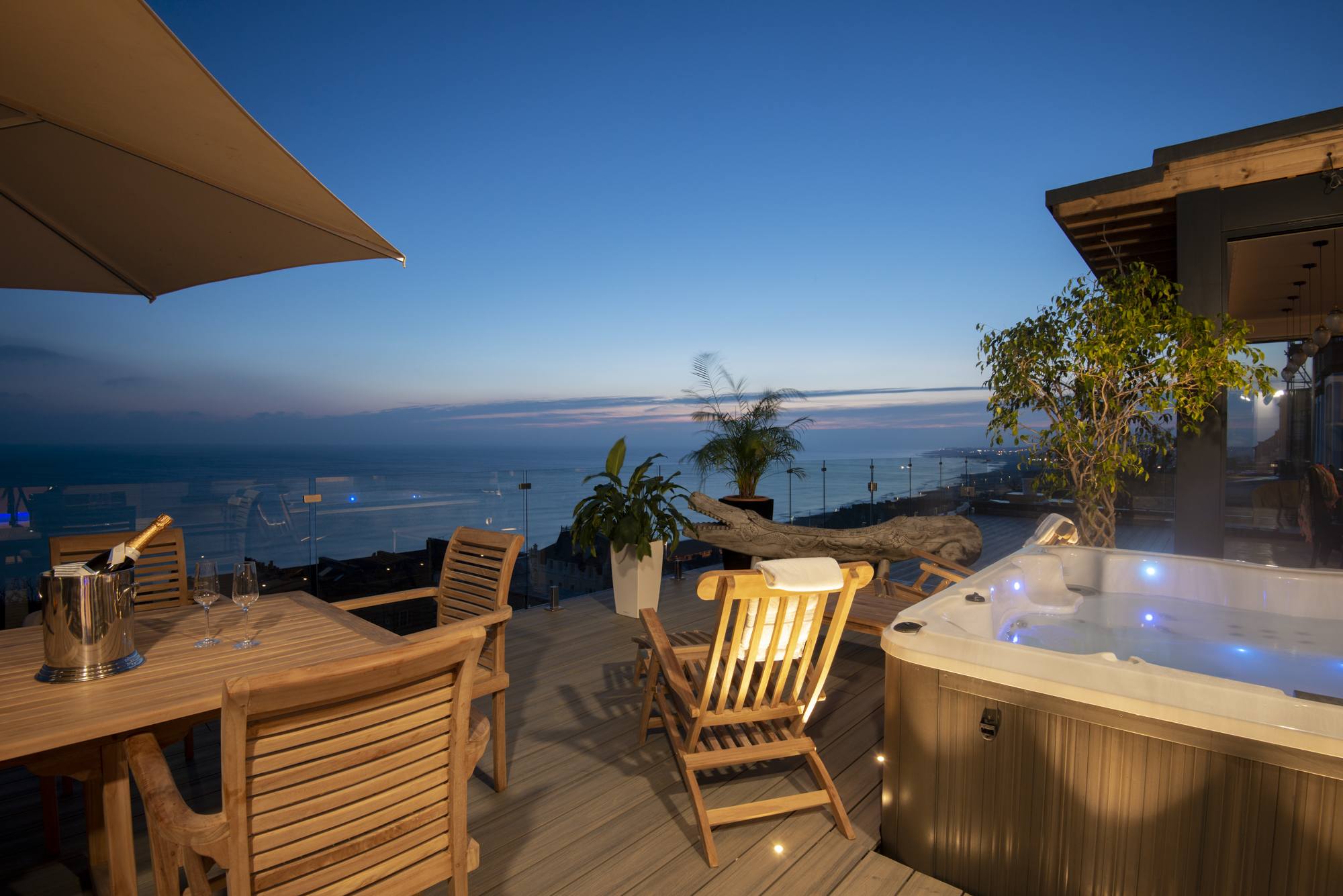 Roof terrace at dusk with hot tub lit up