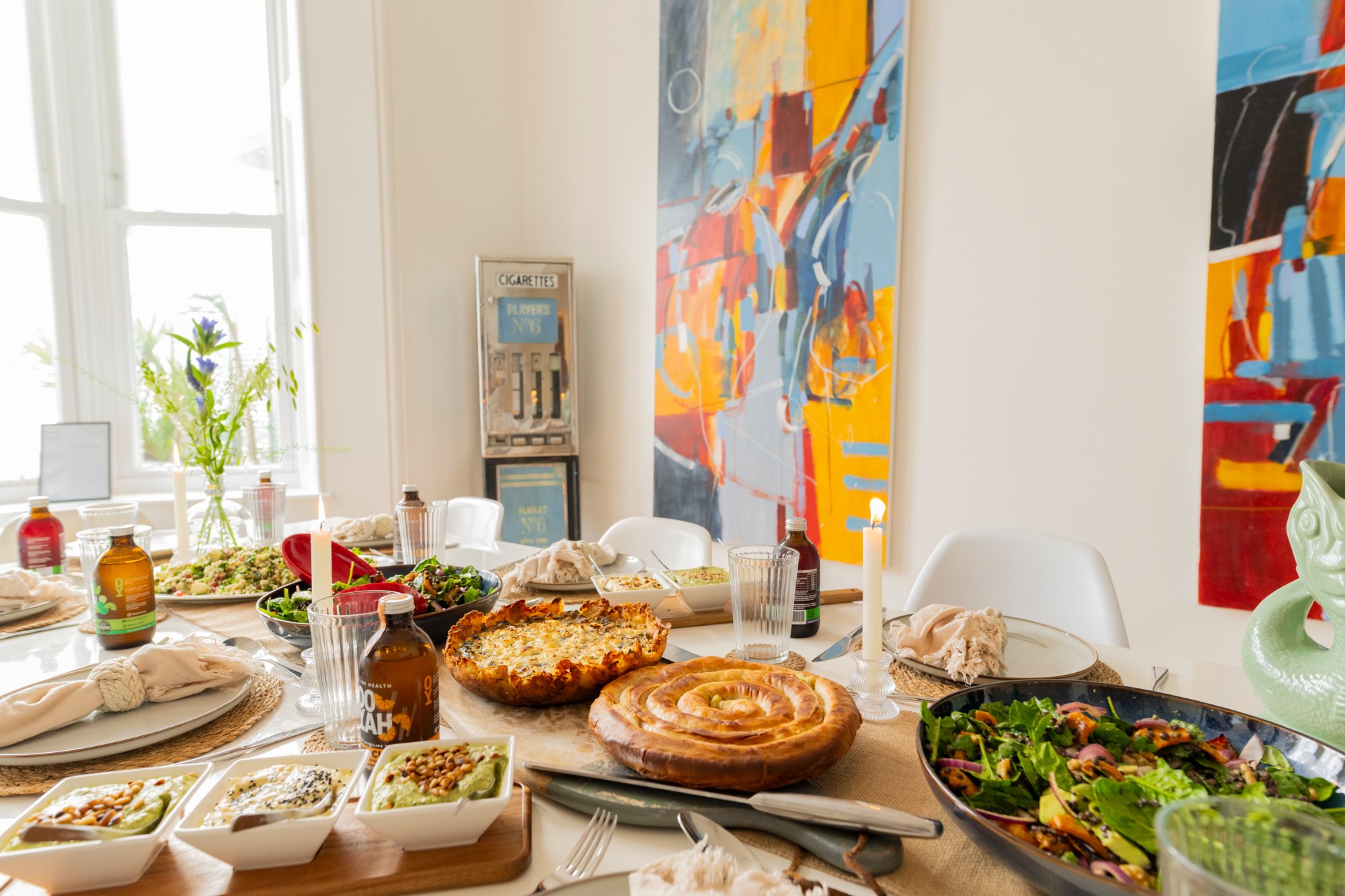 Dining table laid for a feast with colourful artwork