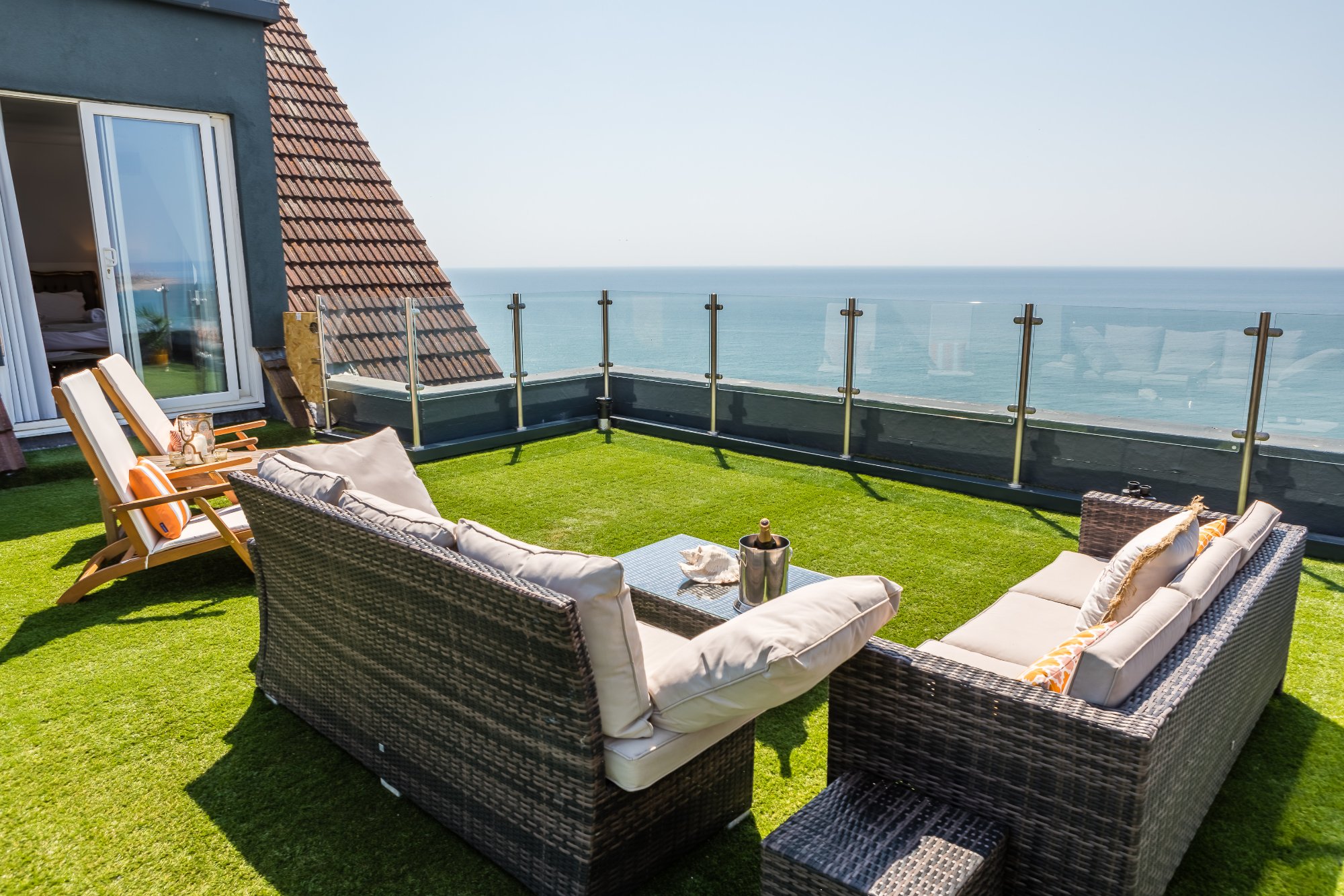 Cliffhanger House roof terrace with rattan sofas and panoramic sea views
