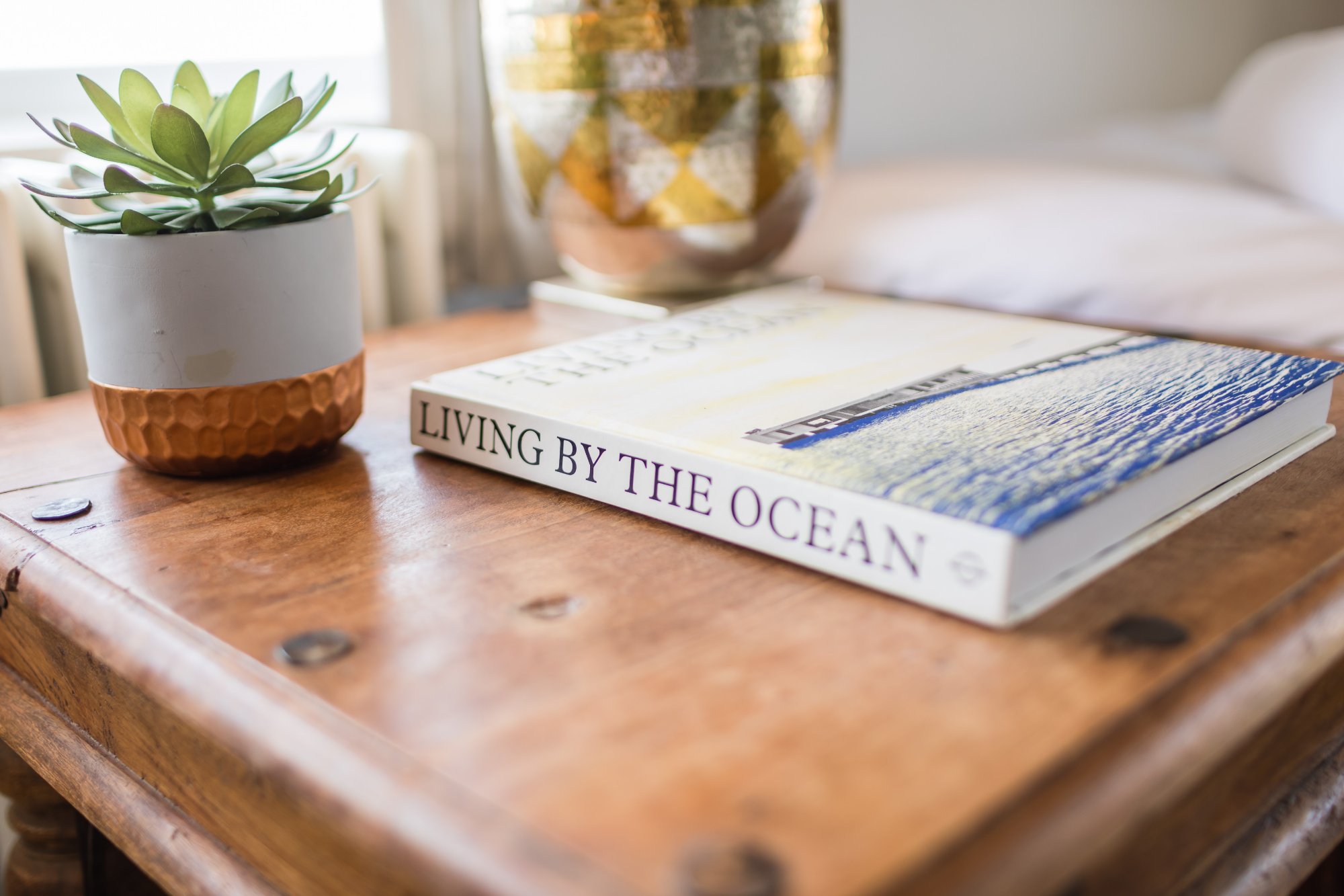 Living by the Ocean book on bedside table